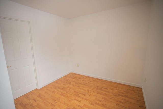 empty room with baseboards and light wood-type flooring