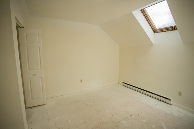 additional living space with a baseboard heating unit and vaulted ceiling with skylight