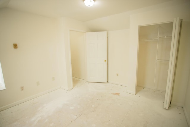 unfurnished bedroom featuring a closet and lofted ceiling