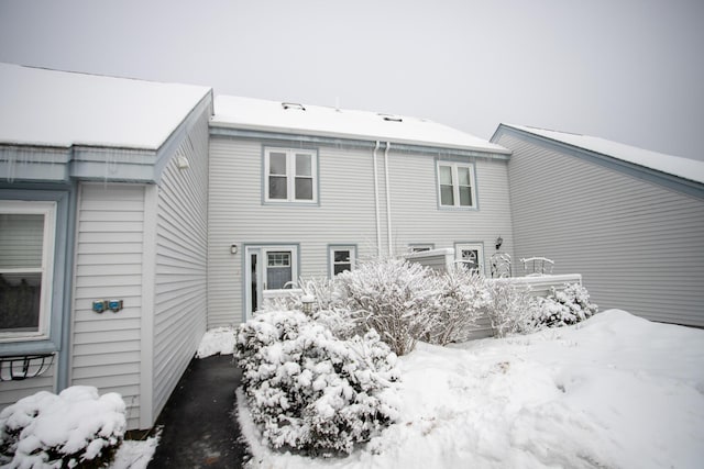 view of snow covered rear of property