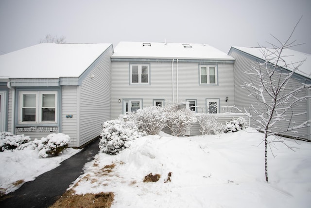 view of snow covered back of property