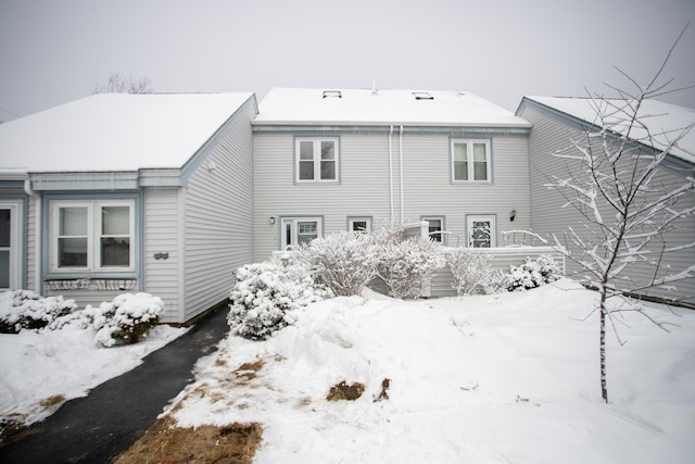 view of snow covered back of property