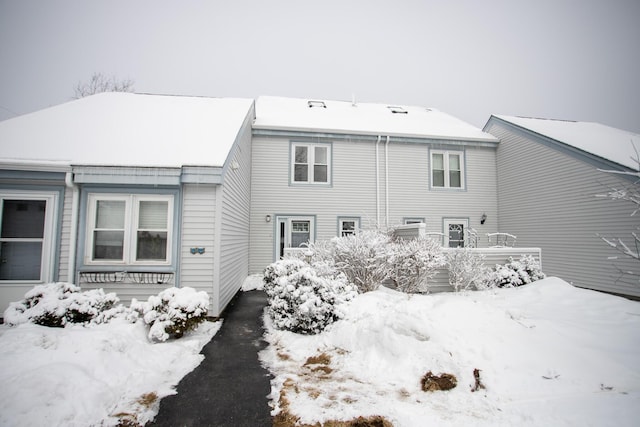 view of snow covered back of property