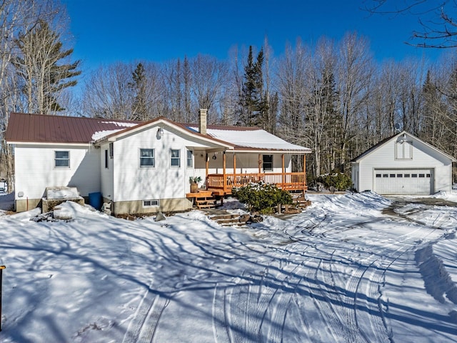 view of front of home with a garage, a porch, an outdoor structure, metal roof, and a chimney