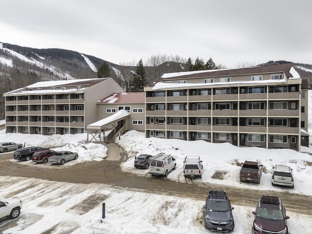 snow covered building featuring a mountain view