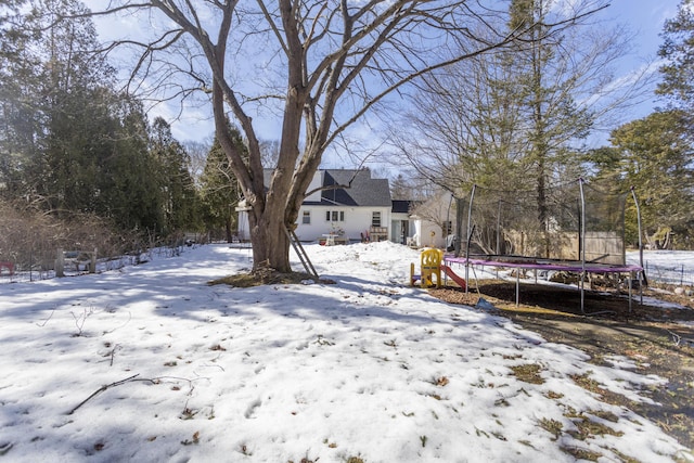 yard covered in snow featuring a trampoline