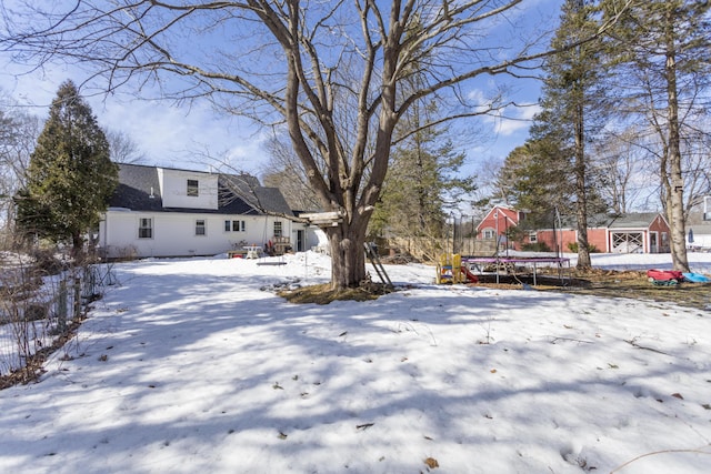 snowy yard featuring a trampoline