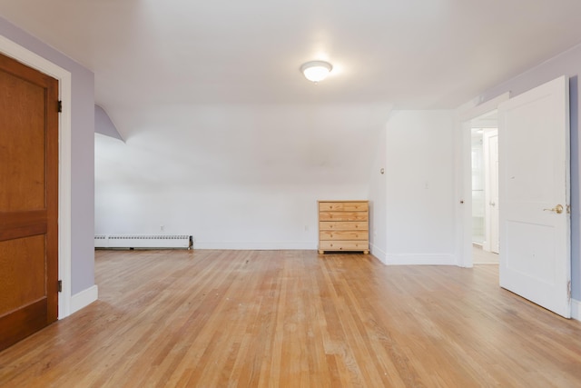 empty room featuring baseboards, baseboard heating, and light wood-style flooring