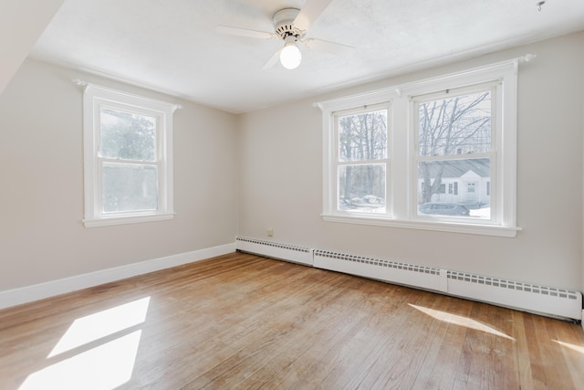 empty room with light wood-style floors, baseboards, baseboard heating, and ceiling fan