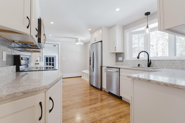 kitchen with white cabinets, tasteful backsplash, appliances with stainless steel finishes, and a sink