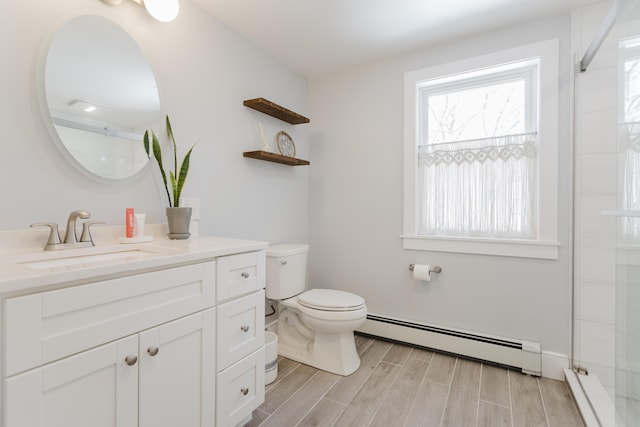 bathroom featuring wood finish floors, toilet, a shower with door, a baseboard radiator, and vanity