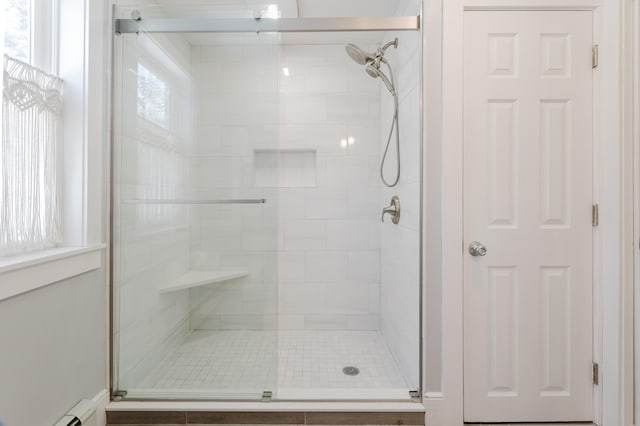 bathroom featuring baseboard heating and a stall shower