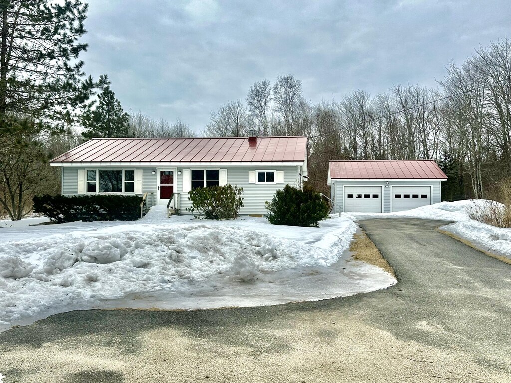 view of front of home with an outbuilding, a standing seam roof, and metal roof