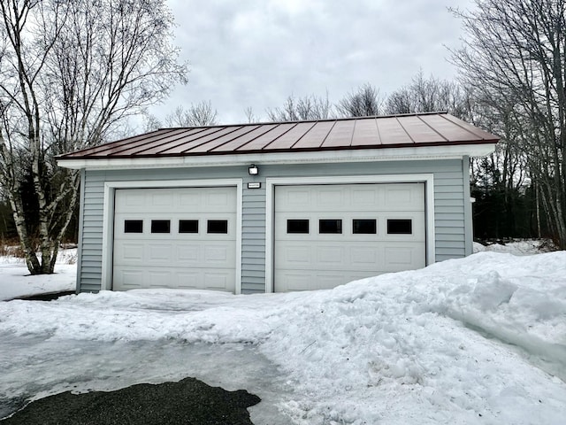 snow covered garage featuring a garage