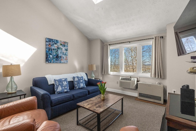 living area with heating unit, a wall mounted AC, vaulted ceiling, a textured ceiling, and baseboards