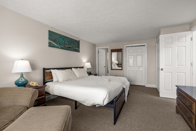 bedroom with a textured ceiling, dark colored carpet, a closet, and baseboards