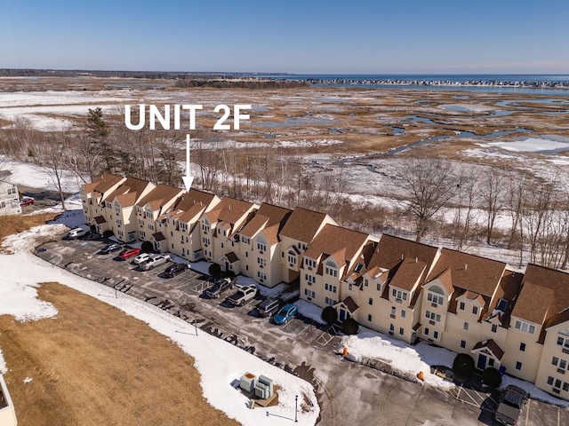 snowy aerial view with a water view and a residential view