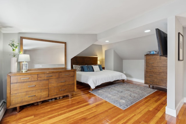 bedroom featuring a baseboard heating unit, baseboards, vaulted ceiling, recessed lighting, and light wood-style flooring