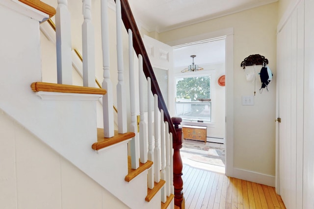 staircase with baseboards, baseboard heating, and hardwood / wood-style floors