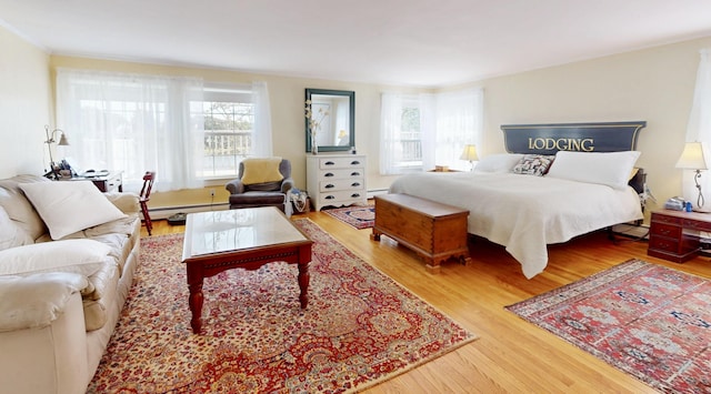 bedroom with a baseboard radiator and wood finished floors