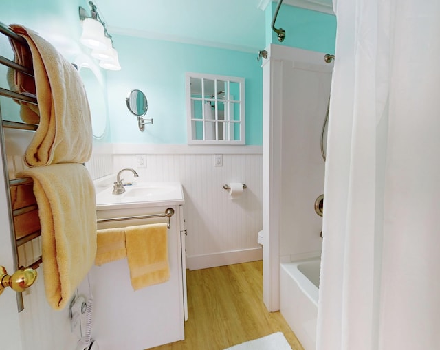 bathroom featuring bathtub / shower combination, toilet, a wainscoted wall, wood finished floors, and vanity