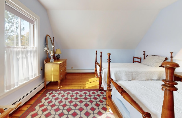 bedroom with a baseboard heating unit, vaulted ceiling, and a baseboard radiator