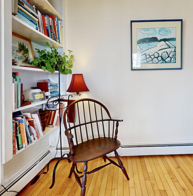 sitting room featuring baseboard heating and wood-type flooring