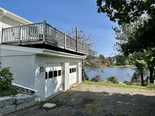 view of property exterior featuring a garage, a water view, and concrete block siding