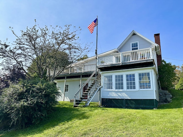 rear view of property with stairs, a chimney, a deck, and a yard