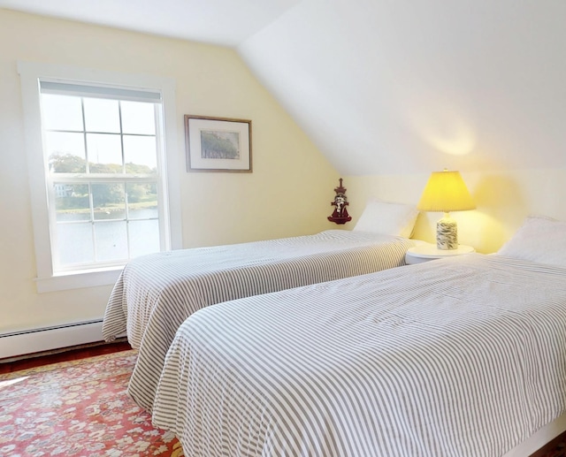 bedroom with multiple windows, a baseboard heating unit, vaulted ceiling, and wood finished floors