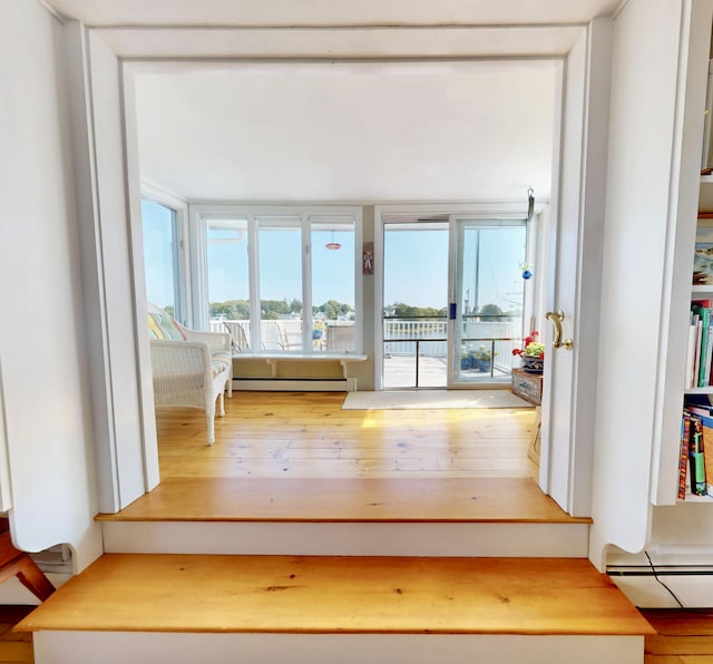 interior space with a baseboard heating unit and hardwood / wood-style flooring