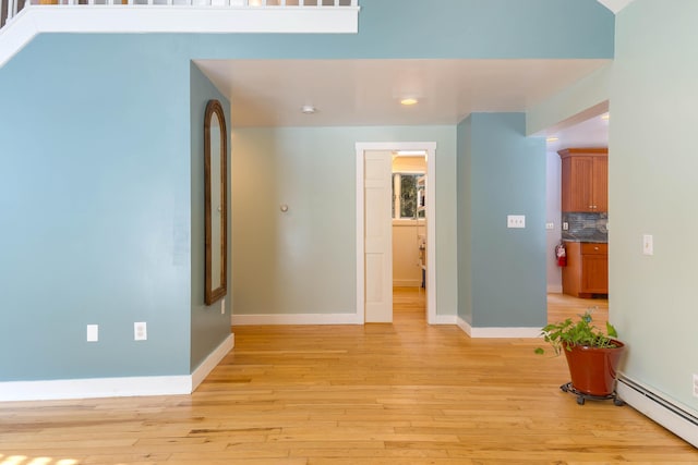 interior space featuring light wood-style flooring, baseboards, and baseboard heating