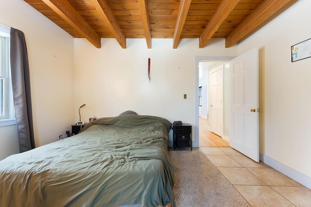 bedroom featuring light tile patterned floors, beam ceiling, wood ceiling, and baseboards