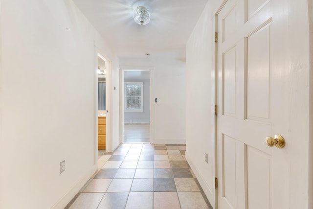 hall with light tile patterned floors, baseboards, and a baseboard radiator