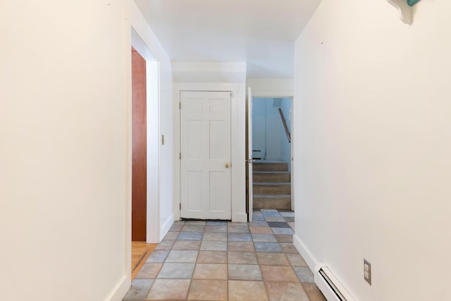 hall with a baseboard heating unit, baseboards, and stairs