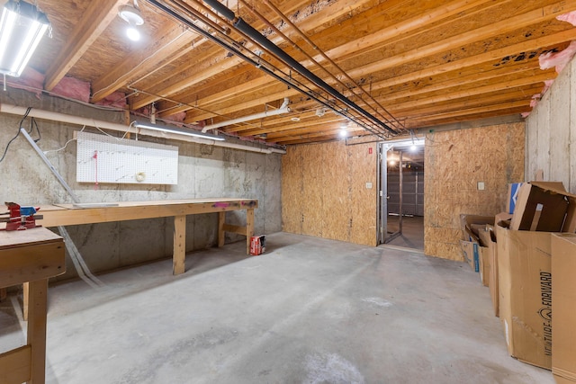 unfinished basement featuring a workshop area