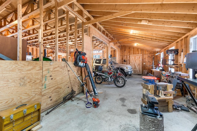 miscellaneous room featuring unfinished concrete flooring and vaulted ceiling