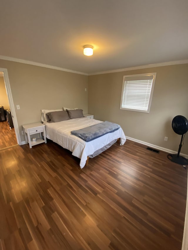 bedroom with visible vents, baseboards, dark wood-style floors, and ornamental molding