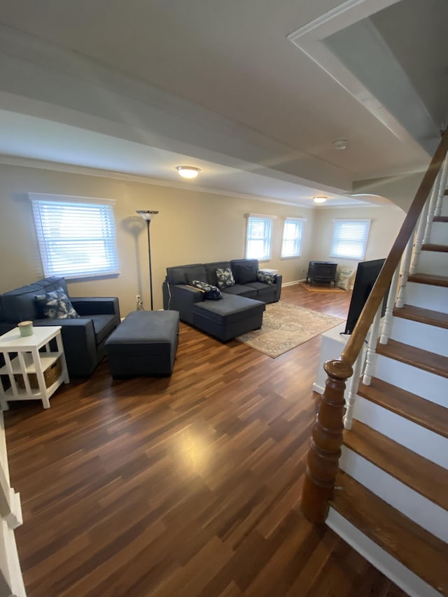 living area with arched walkways, wood finished floors, and stairs