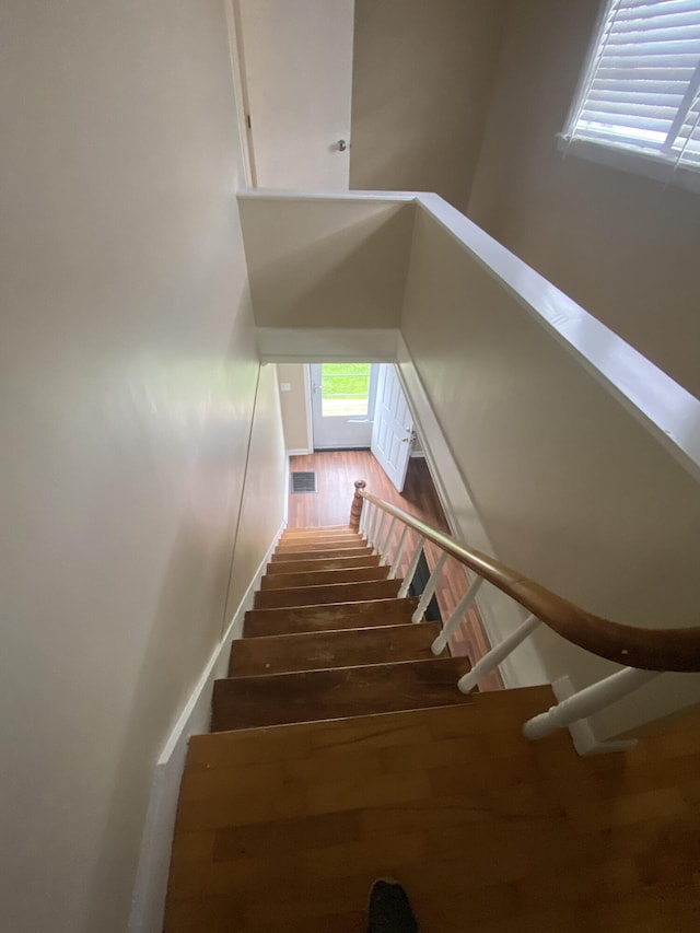 stairs featuring wood finished floors and visible vents