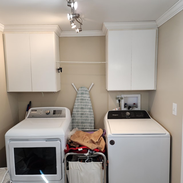 laundry room featuring cabinet space, washer and dryer, and crown molding