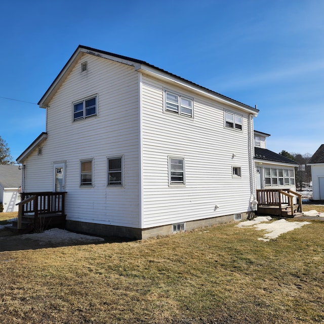 rear view of property with a lawn