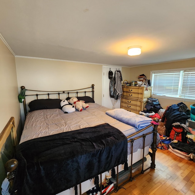 bedroom featuring wood finished floors and crown molding