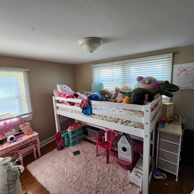 bedroom with wood finished floors and baseboards