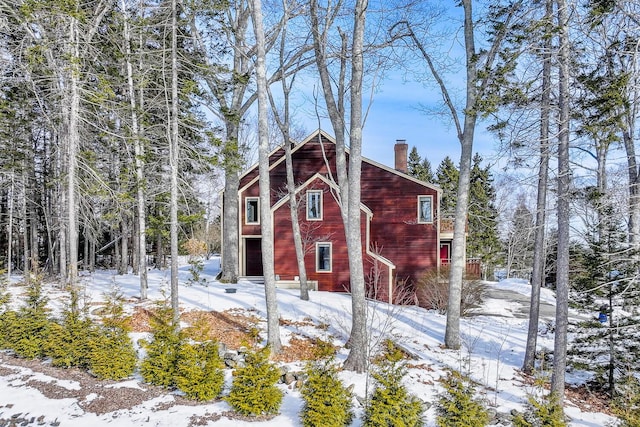 view of snowy exterior featuring a chimney