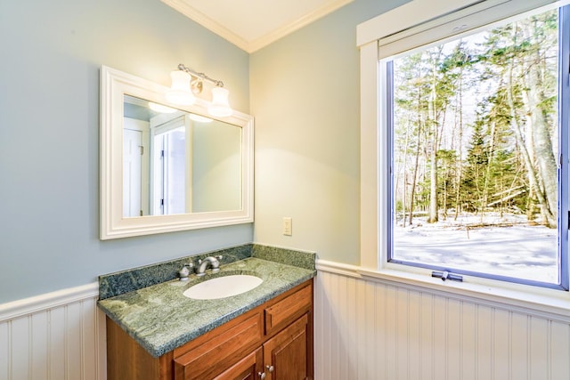 bathroom featuring a wainscoted wall, vanity, and crown molding