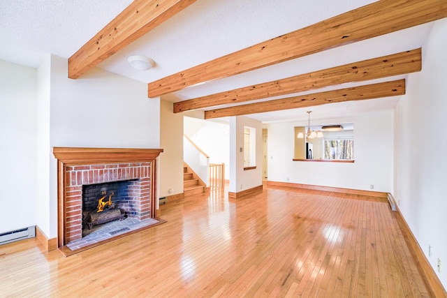 unfurnished living room with wood-type flooring, a fireplace, beamed ceiling, and baseboards