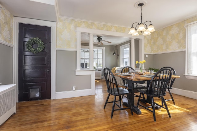 dining room with radiator, wallpapered walls, and light wood-style floors