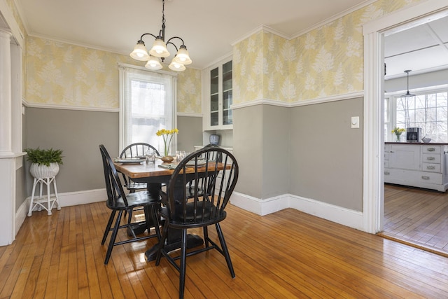 dining room featuring wainscoting, wallpapered walls, and hardwood / wood-style floors