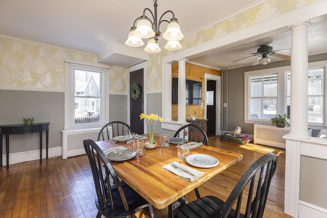 dining room featuring wallpapered walls, decorative columns, wood-type flooring, and wainscoting